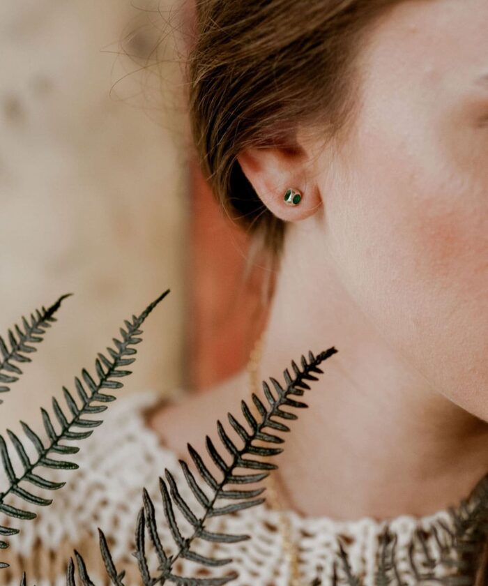 Delicate green gemstone earrings worn by Monica Varela, showcasing elegant jewelry style.