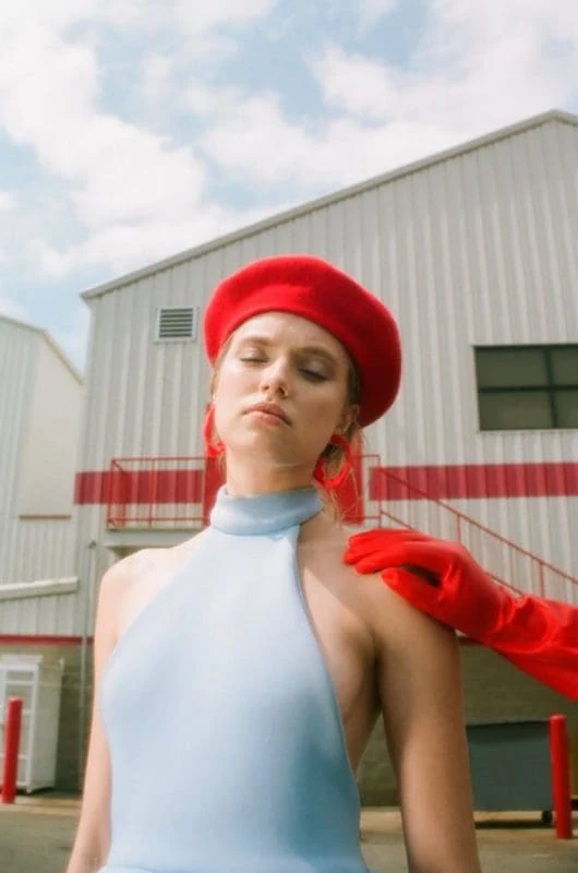 Beautiful woman in red beret and gloves outdoors.