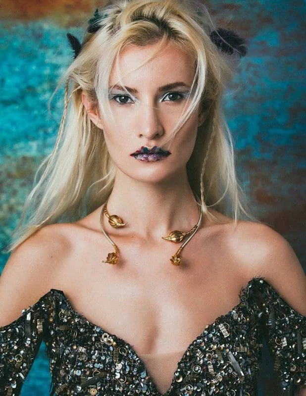 Vivid portrait of Monica Varela showcasing avant-garde makeup, statement jewelry, and a glamorous sequin outfit.