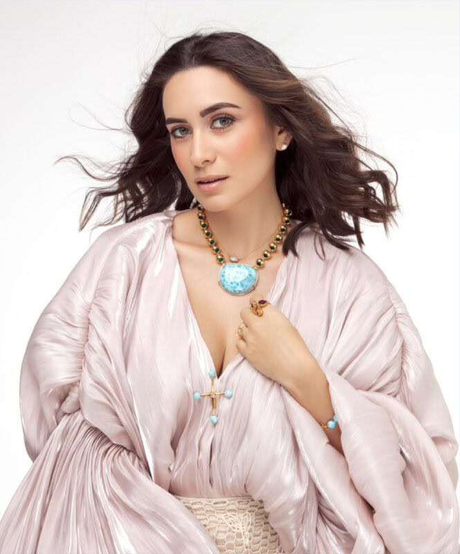 Elegant woman wearing designer necklaces and rings, showcasing luxury jewelry styles.