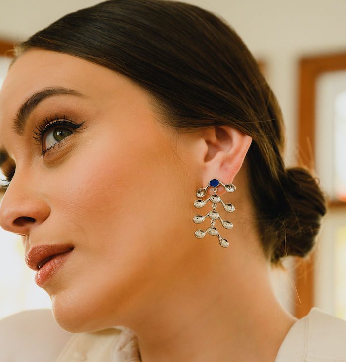 Beautiful woman wearing silver venule earrings with dangling elements, perfect for sophisticated style.