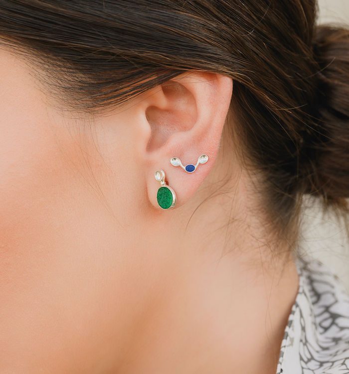 Elegant ear piercings with vibrant green and blue accents, perfect for a stylish look.