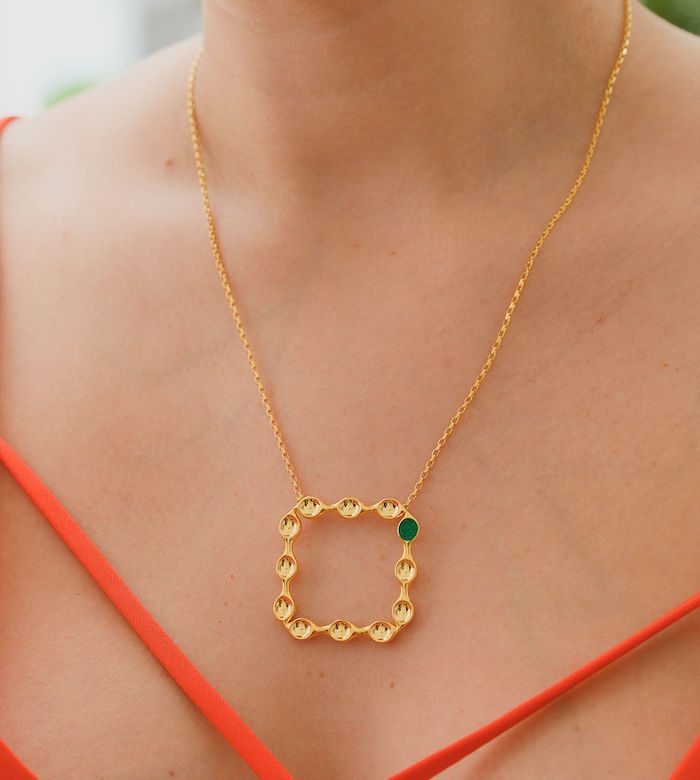 Elegant gold square pendant necklace with green gemstone detail. Perfect for jewelry lovers.