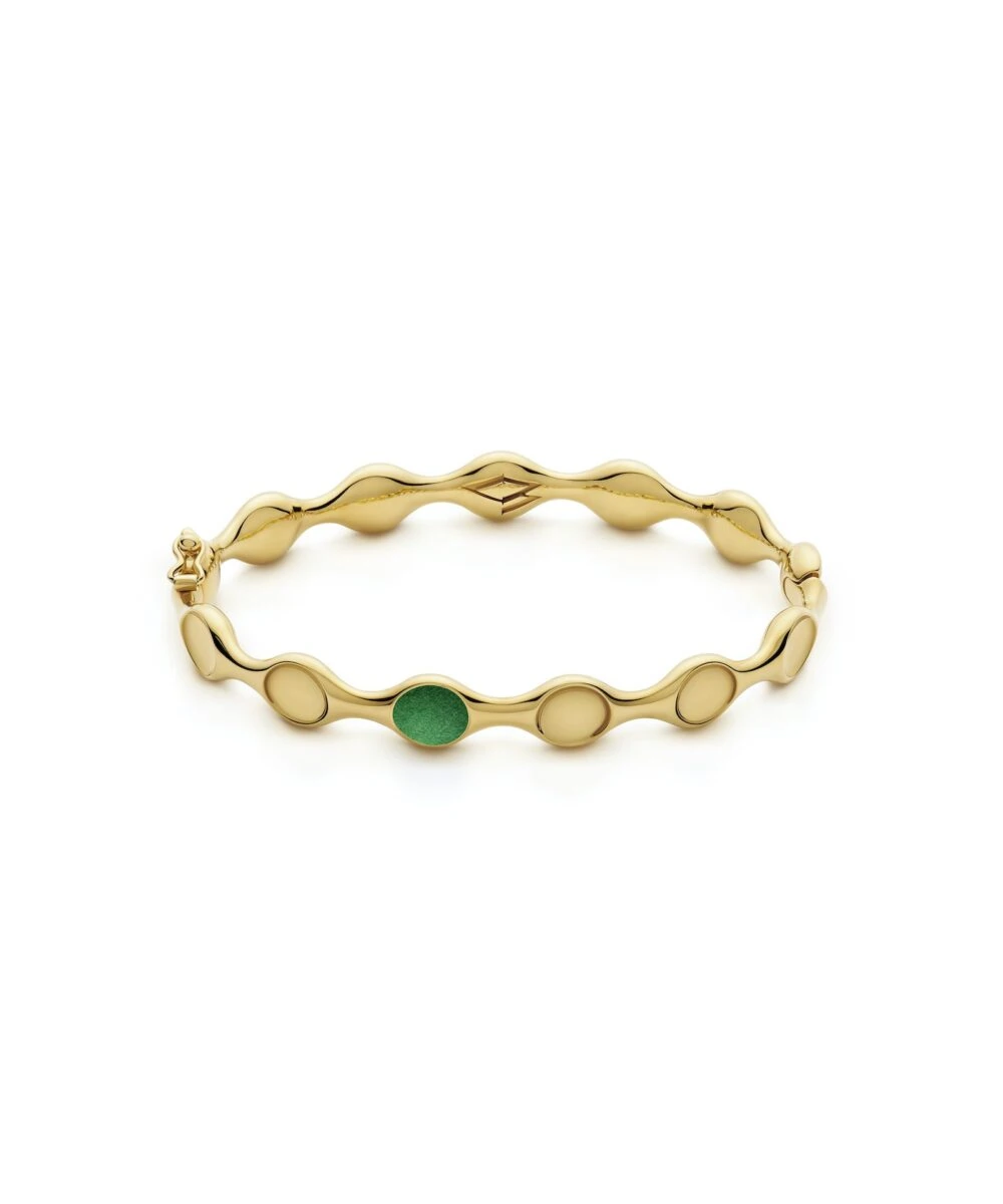 Luxurious gold bangle featuring a wavy design and a striking green embellishment. Perfect for stylish accessorizing.