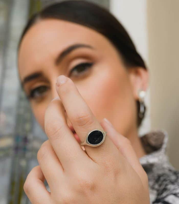 Elegant black gemstone ring on woman's finger for fashion and jewelry enthusiasts.