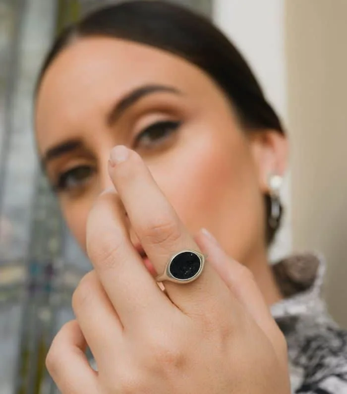 Elegant black gemstone ring on woman's finger for fashion and jewelry enthusiasts.