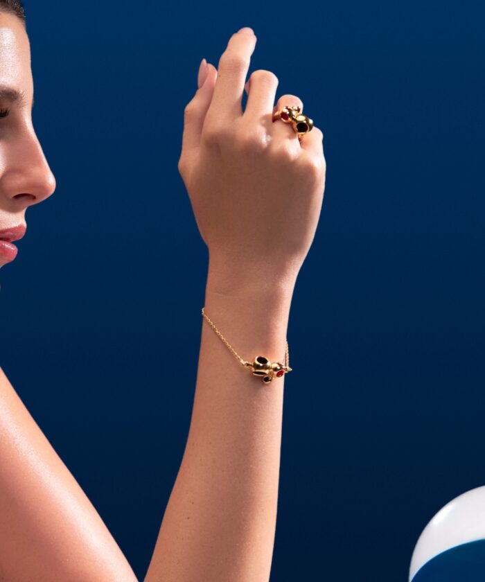 Luxury gold jewelry featuring black and red stones, designed by Monica Varela.