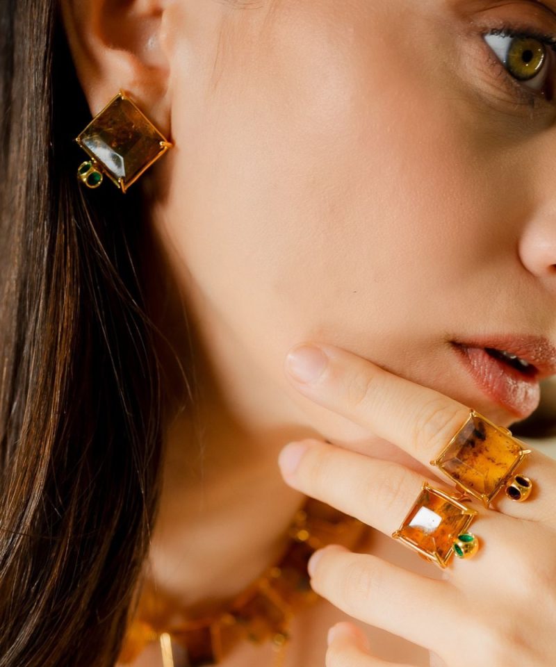 Duet Amber Studs in 925 sterling silver with 18k gold plating and Blazing Burgundy accents, worn on model's ear