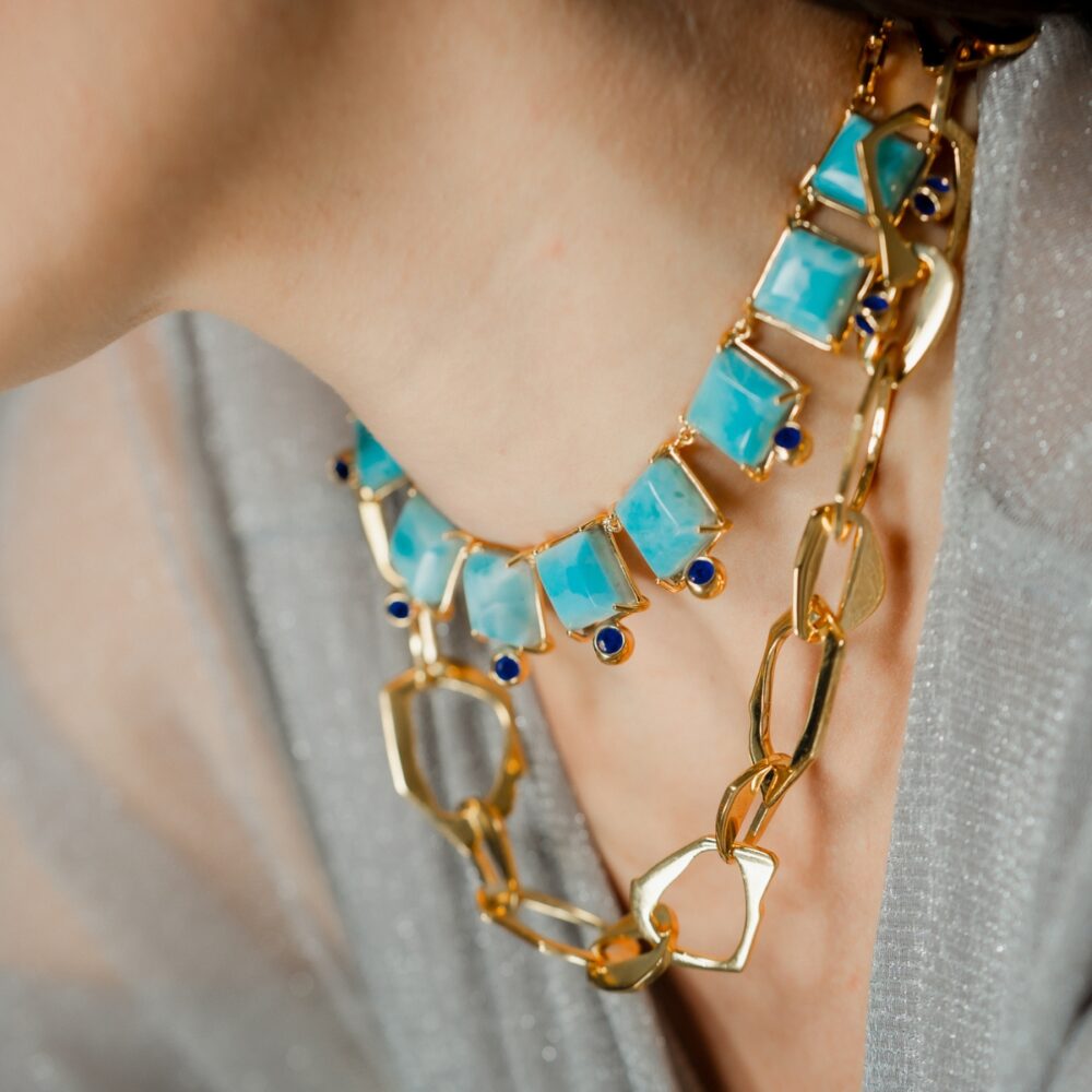 Stunning turquoise and gold chain necklace featuring geometric and heart-shaped charms for a chic style.