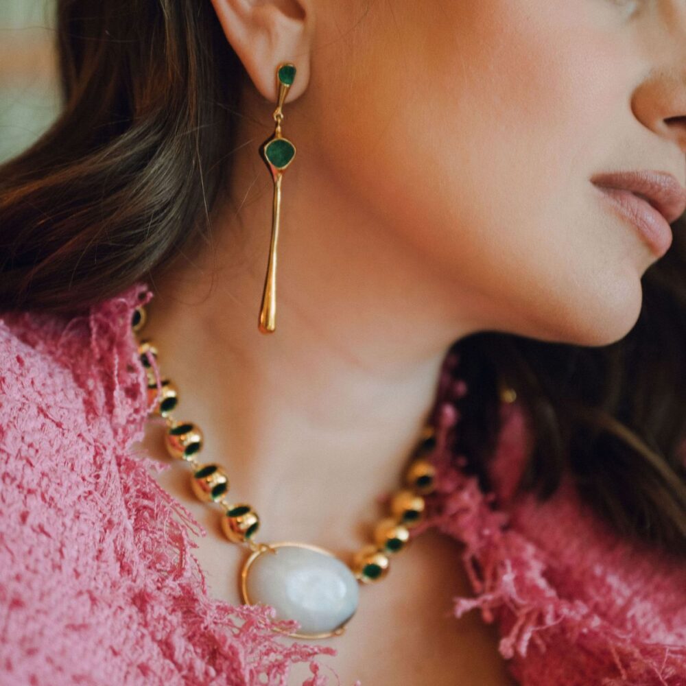 Luxurious gold and green jewelry set featuring a pearl necklace and drop earrings for sophisticated look.