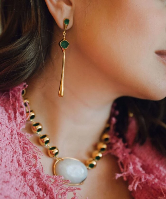 Luxurious gold and green jewelry set featuring a pearl necklace and drop earrings for sophisticated look.