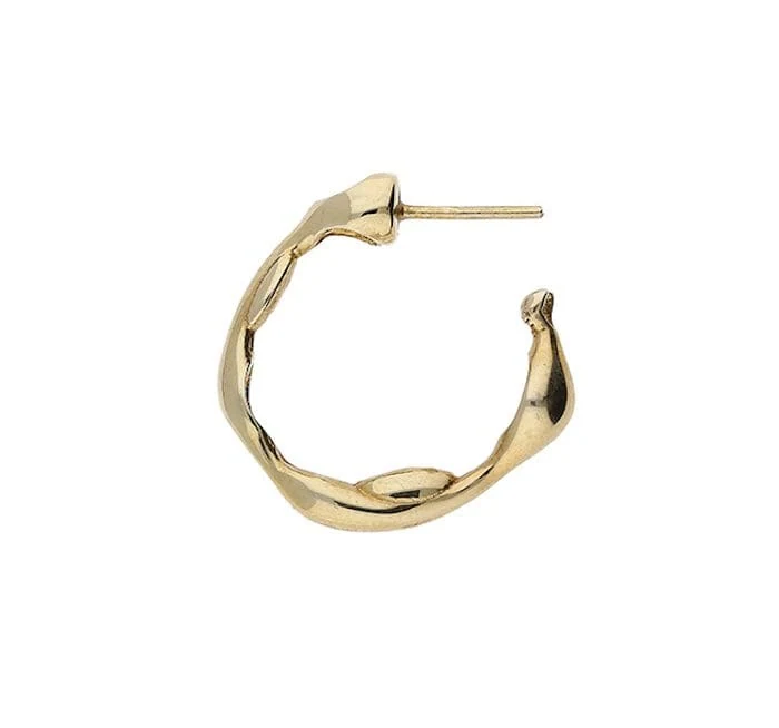 Close-up of ear showcasing gold hoops and delicate stacking earrings.