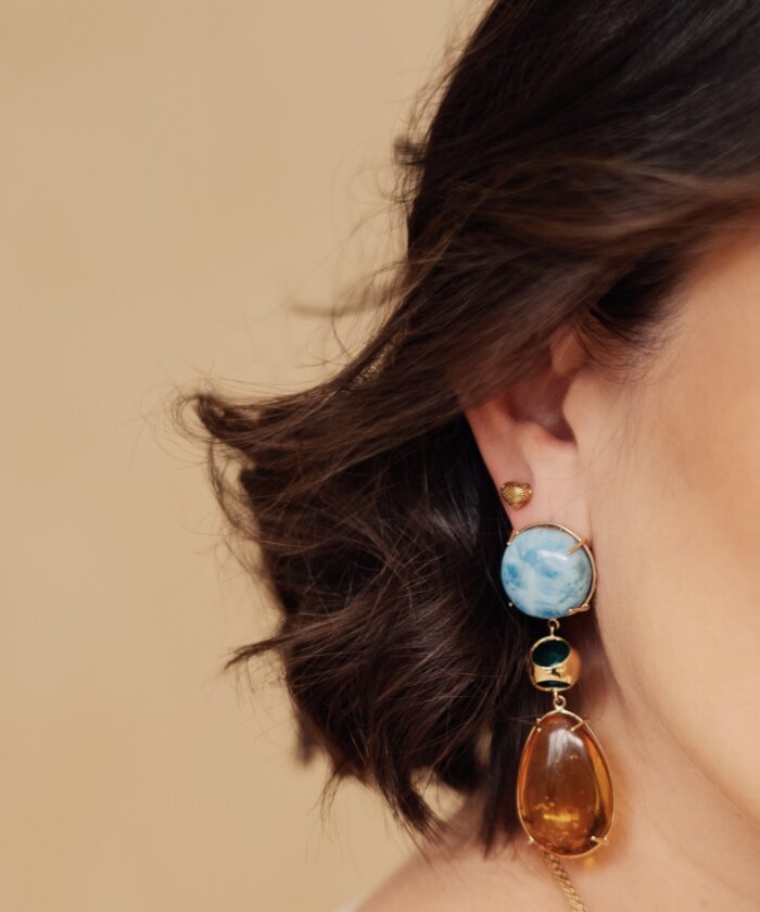 Beautiful dangle earrings featuring larimar and amber stones with gold accents, perfect for a stylish look.
