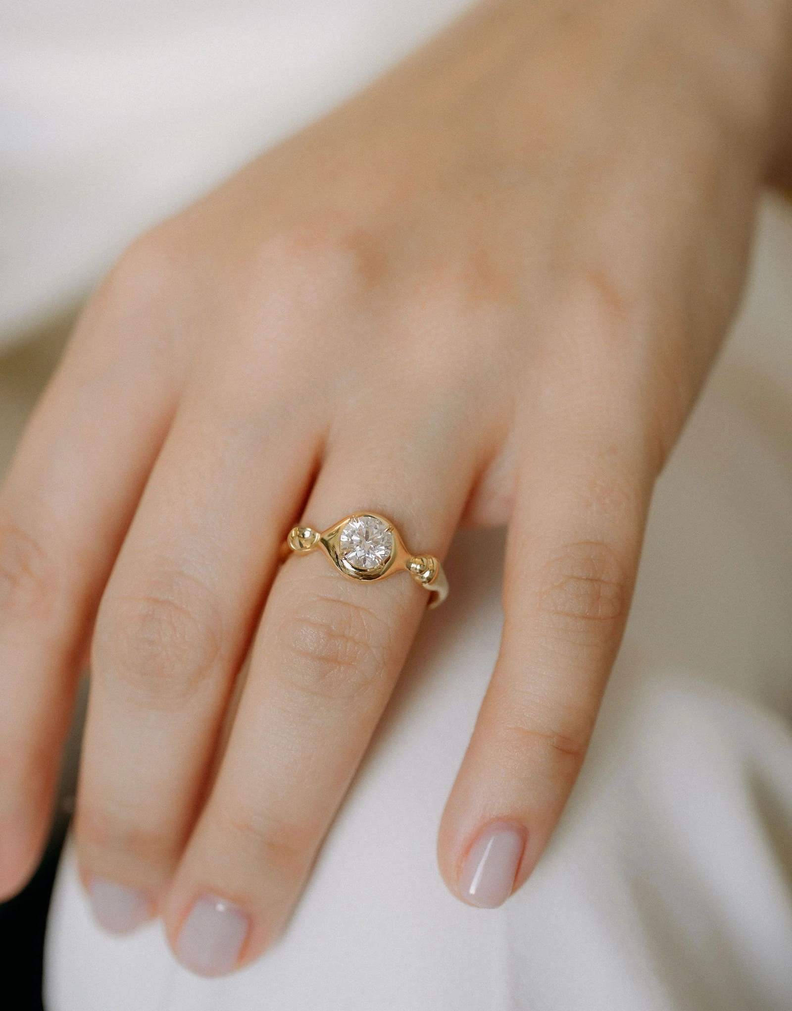 Elegant Gold Ring with Diamond Close-up of a stunning gold ring featuring a central diamond on a woman's finger. Perfect for jewelry lovers.