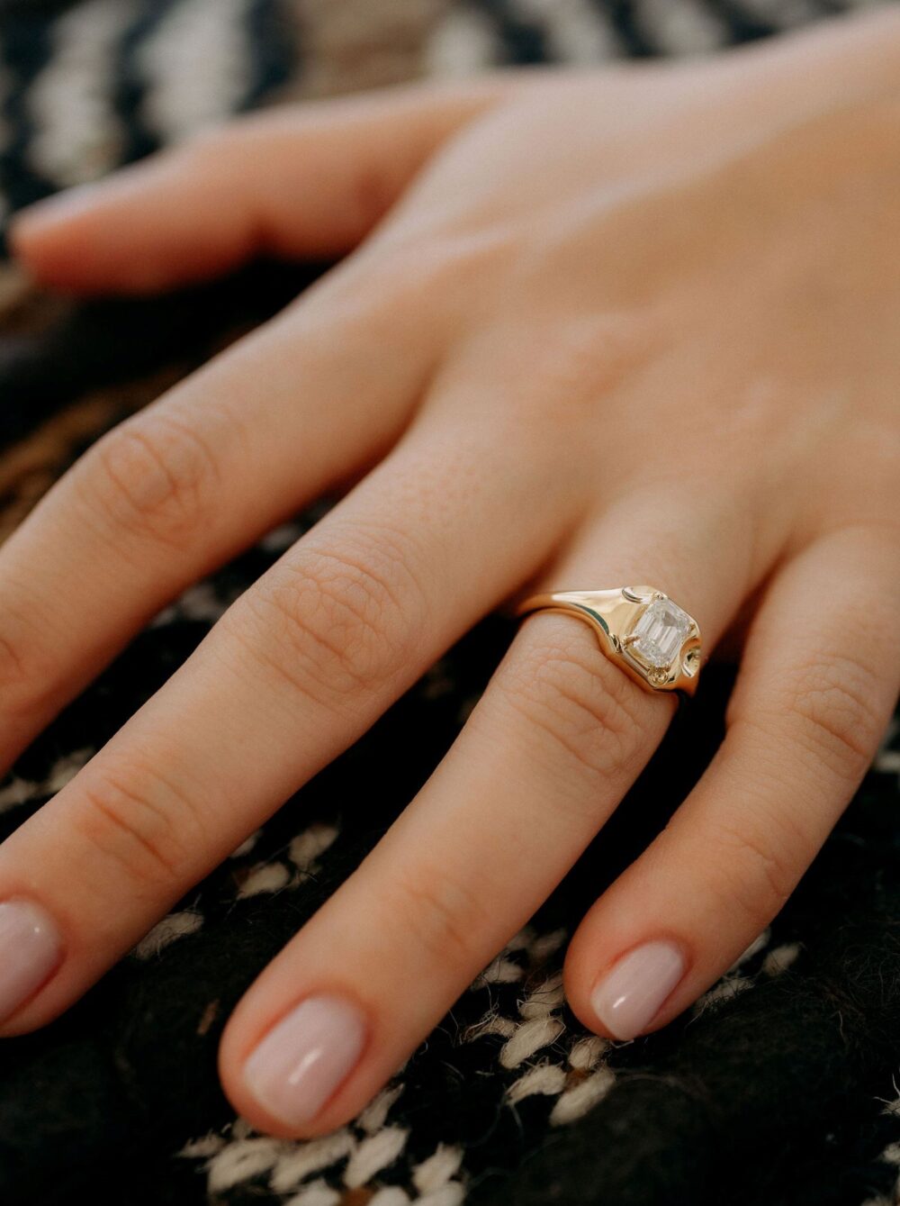 Close-up of diamond cut ring on a woman's finger, showcasing fine jewelry craftsmanship.