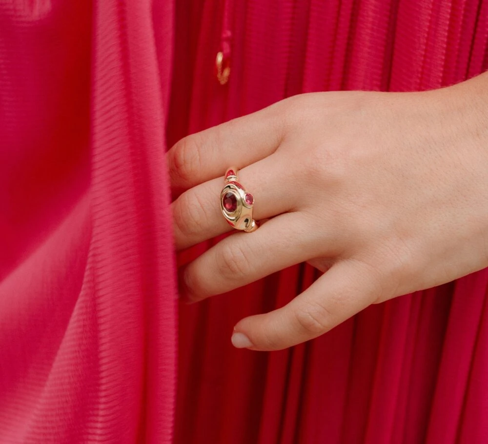 Stunning ruby ring with gold detailing and red gemstones, perfect for stylish jewelry lovers.