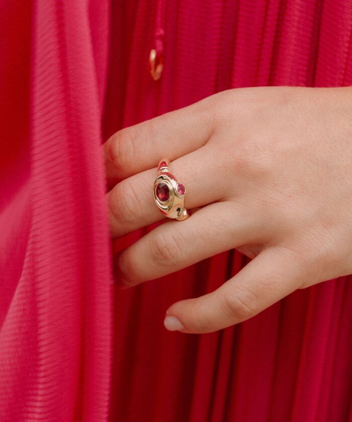 Stunning ruby ring with gold detailing and red gemstones, perfect for stylish jewelry lovers.