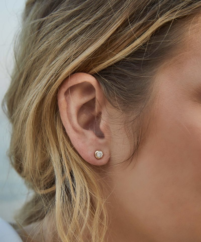 Whisper Diamond Stud Earrings in 18k yellow gold, worn on model's ear