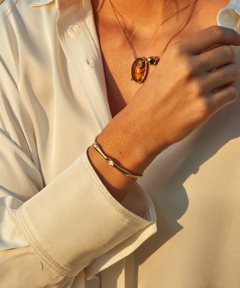 Fauli Bangle Medium in 18k yellow gold, worn on model's wrist