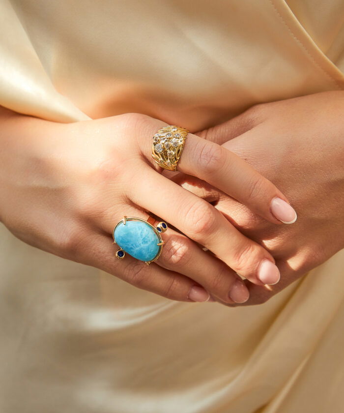 Stunning larimar gemstone ring with intricate gold design, perfect for elegant jewelry lovers.