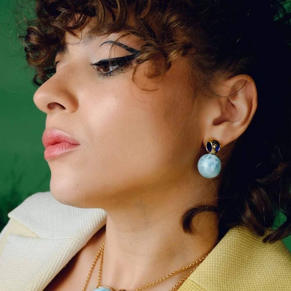 Dainty Larimar gemstone studs with gold accents, perfect for sophisticated jewelry looks.