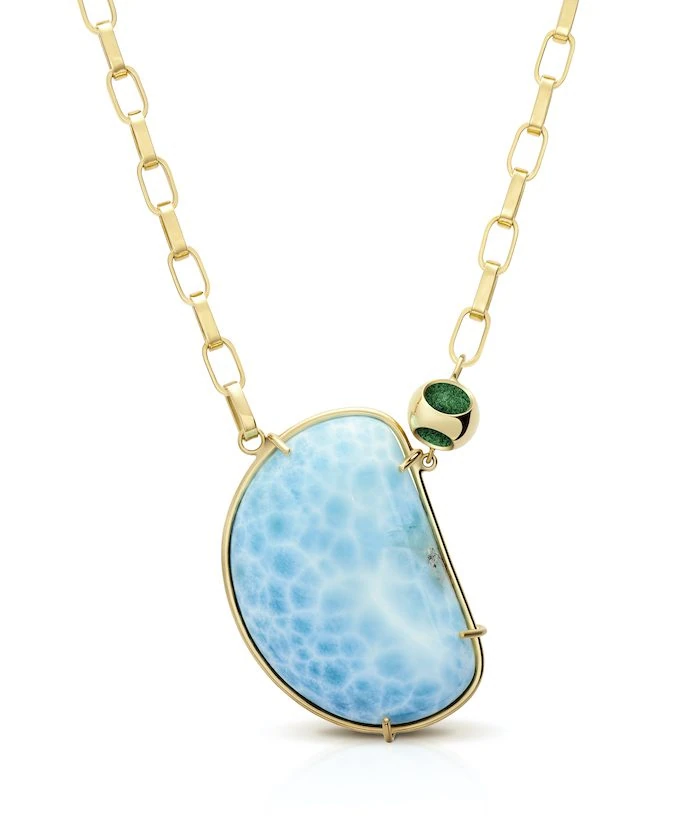 Elegant larimar pendant with gold chain, perfect for stylish jewelry lovers.