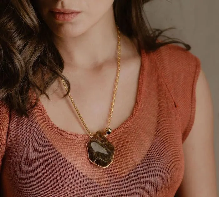 Close-up of Monica Varela wearing a statement pendant necklace.