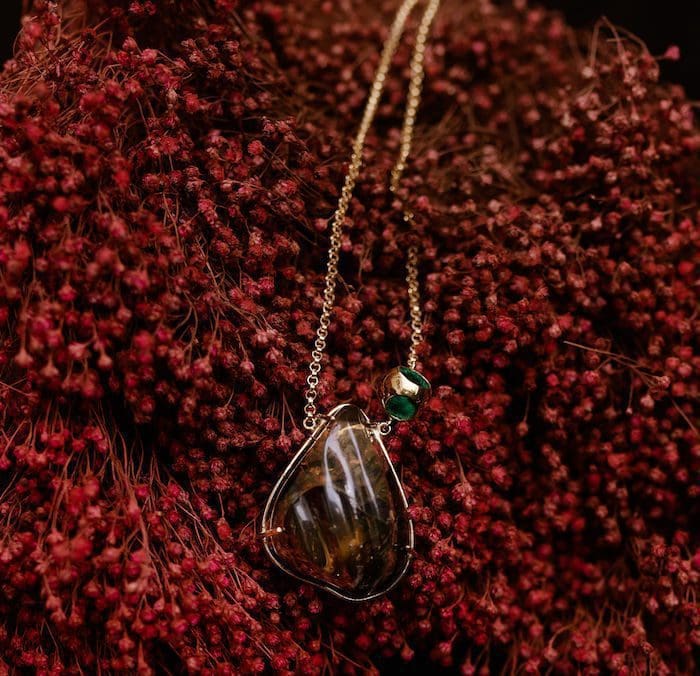 Elegant amber necklace featuring green accents on a delicate chain, perfect for sophisticated jewelry collection.