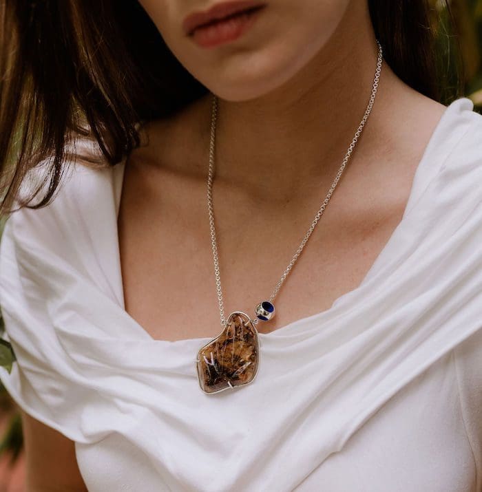 Elegant amber pendant necklace with blue accent, perfect for stylish accessories.