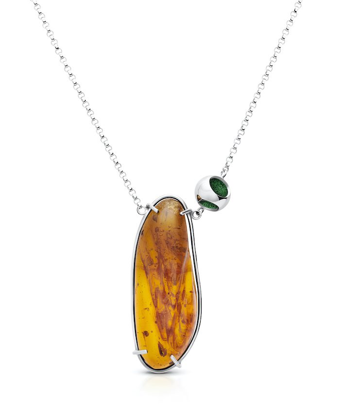Elegant amber pendant with silver chain and green-accented bead for sophisticated jewelry style.