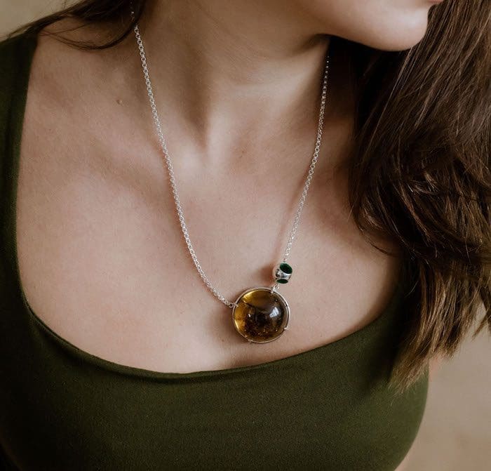 Delicate amber pendant necklace with silver chain for stylish elegance. Perfect jewelry for any outfit.