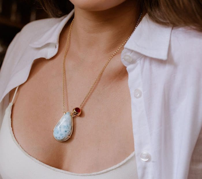 Larimar pendant jewelry with gold chain, unique ocean-blue gemstone, elegant fashion accessory.
