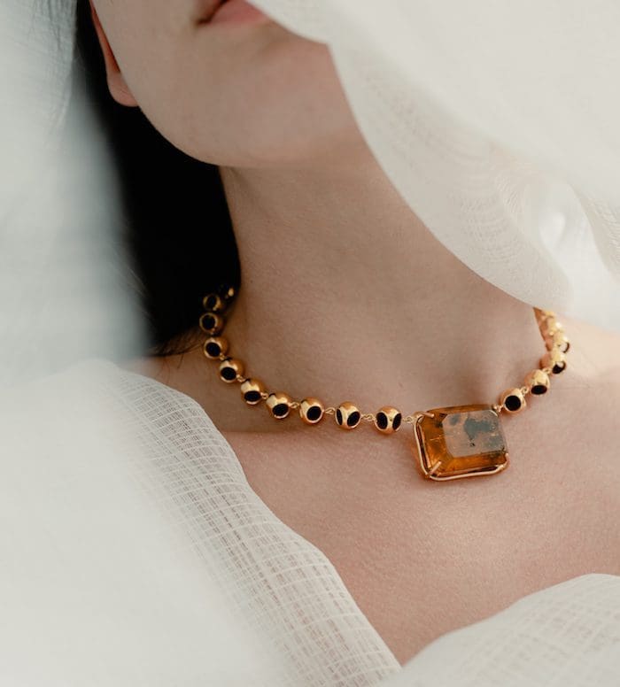 Elegant amber infinity choker with black accents, perfect for luxury jewelry lovers.