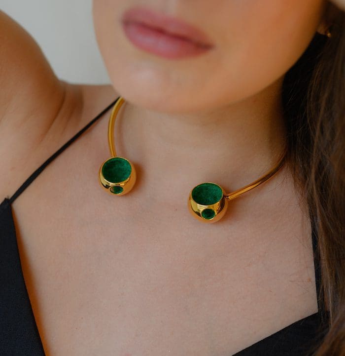 Gold necklace with green stone accents, perfect for fashionable accessories.