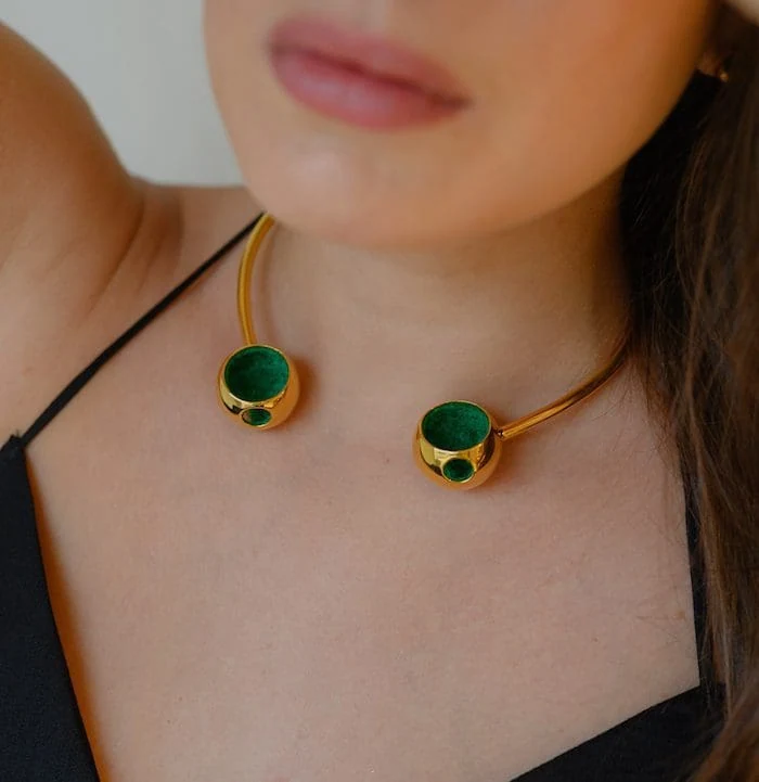 Gold necklace with green stone accents, perfect for fashionable accessories.