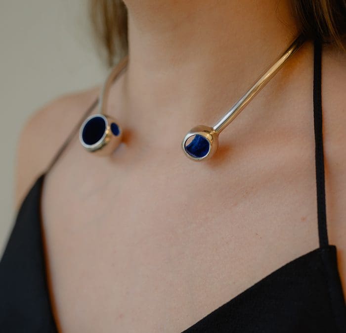 Elegant gold and blue pendant necklace on a woman.