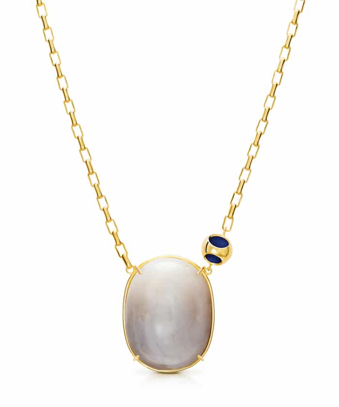 Elegant moonstone pendant necklace with gold chain and dark blue accents. Perfect for sophisticated jewelry lovers.