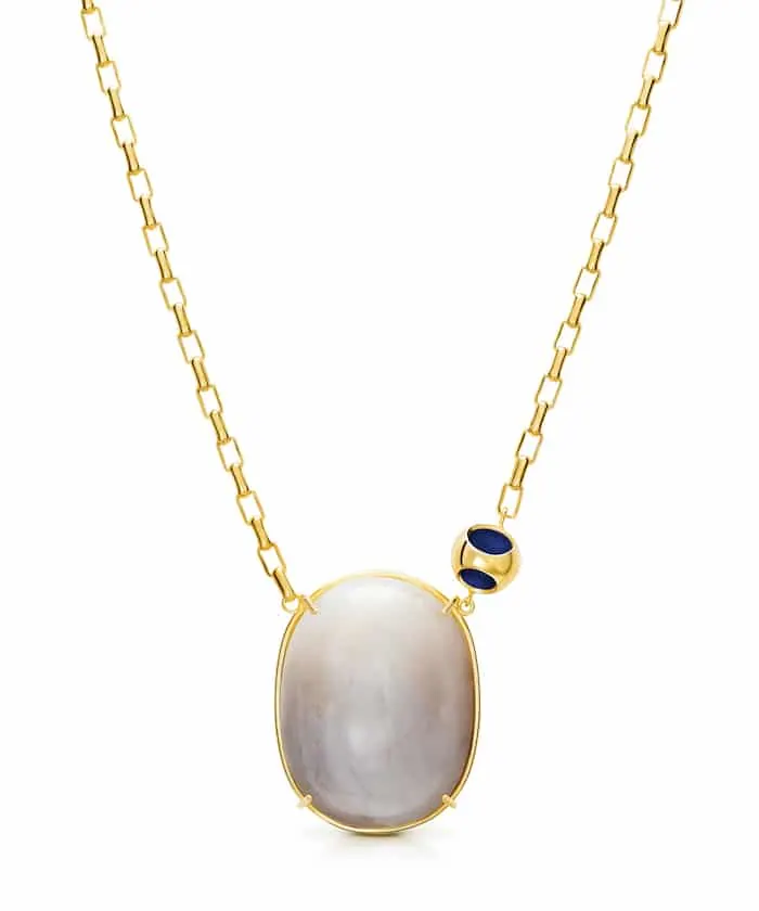 Elegant moonstone pendant necklace with gold chain and dark blue accents. Perfect for sophisticated jewelry lovers.