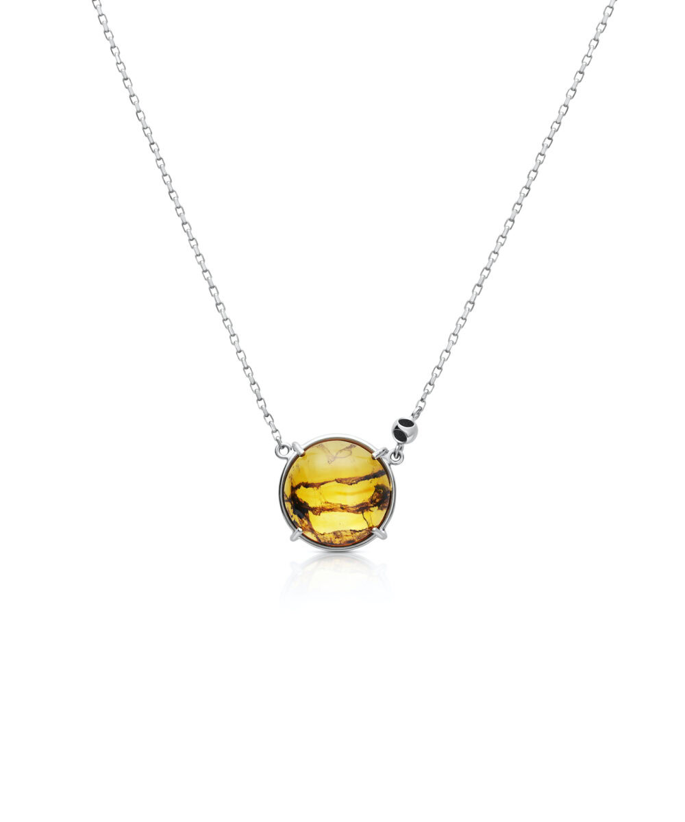 Elegant round amber pendant with silver chain, perfect jewelry for stylish women.