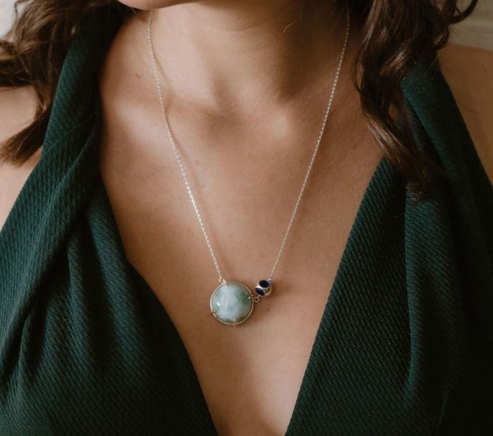 Larimar pendant with silver chain and dark blue gemstone accent.