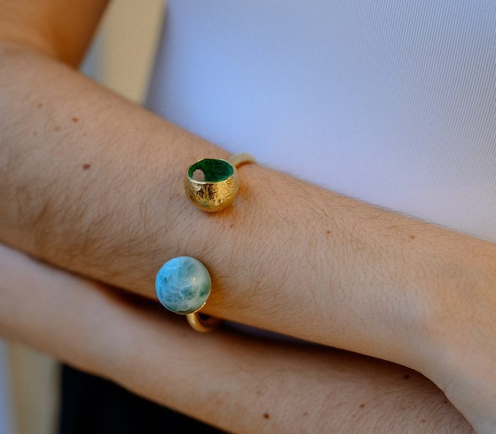 Stunning Larimar sphere bangle with gold accents and vibrant blue stone showcase.
