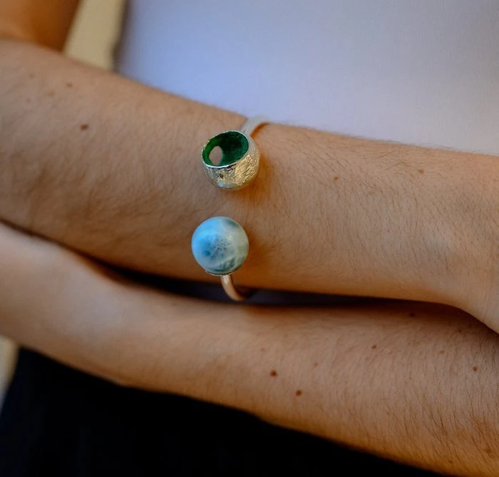 Beautiful larimar sphere jewelry featuring a Larimar bangle on a person's wrist, showcasing elegant natural gemstone design.