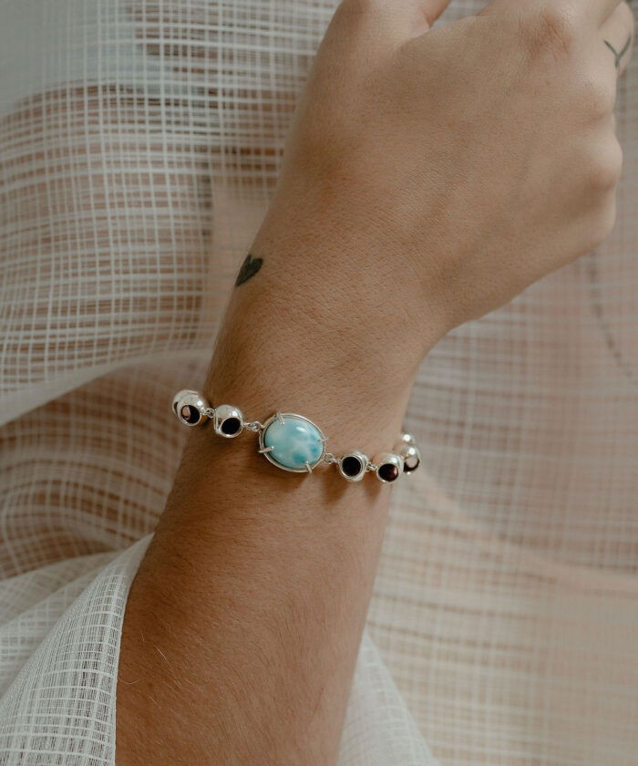 Beautiful larimar infinity bracelet with black and white accents, perfect jewelry for elegant summer styles.