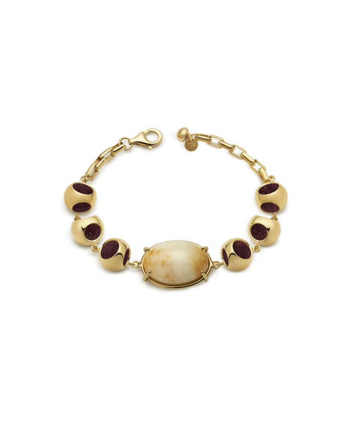 Delicate gold bracelet featuring a stunning moonstone centerpiece and deep red accent beads. Perfect for stylish accessorizing.