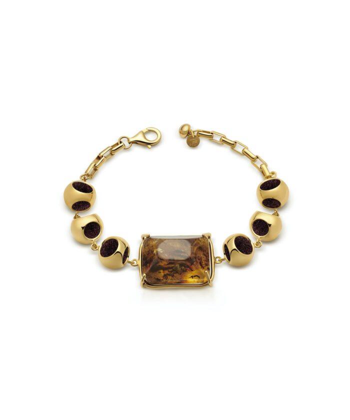 Luxurious amber and gold bracelet featuring a striking rectangular amber centerpiece and round gold beads with dark accents.