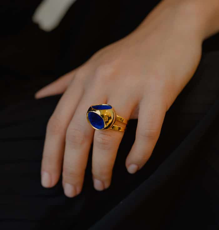 Elegant gold double band ring with a striking deep blue gemstone design. Perfect for stylish accessories.