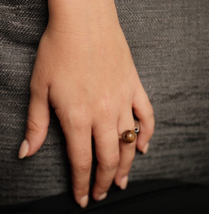 Amber ring on finger showcasing trendy jewelry.