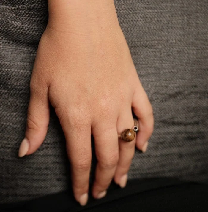 Amber ring on finger showcasing trendy jewelry.