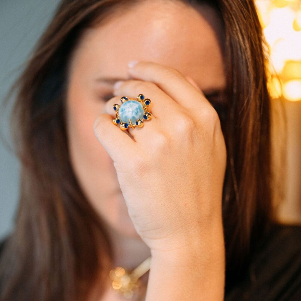 Close-up of Monica Varela ring with a moonstone and navy blue accents.