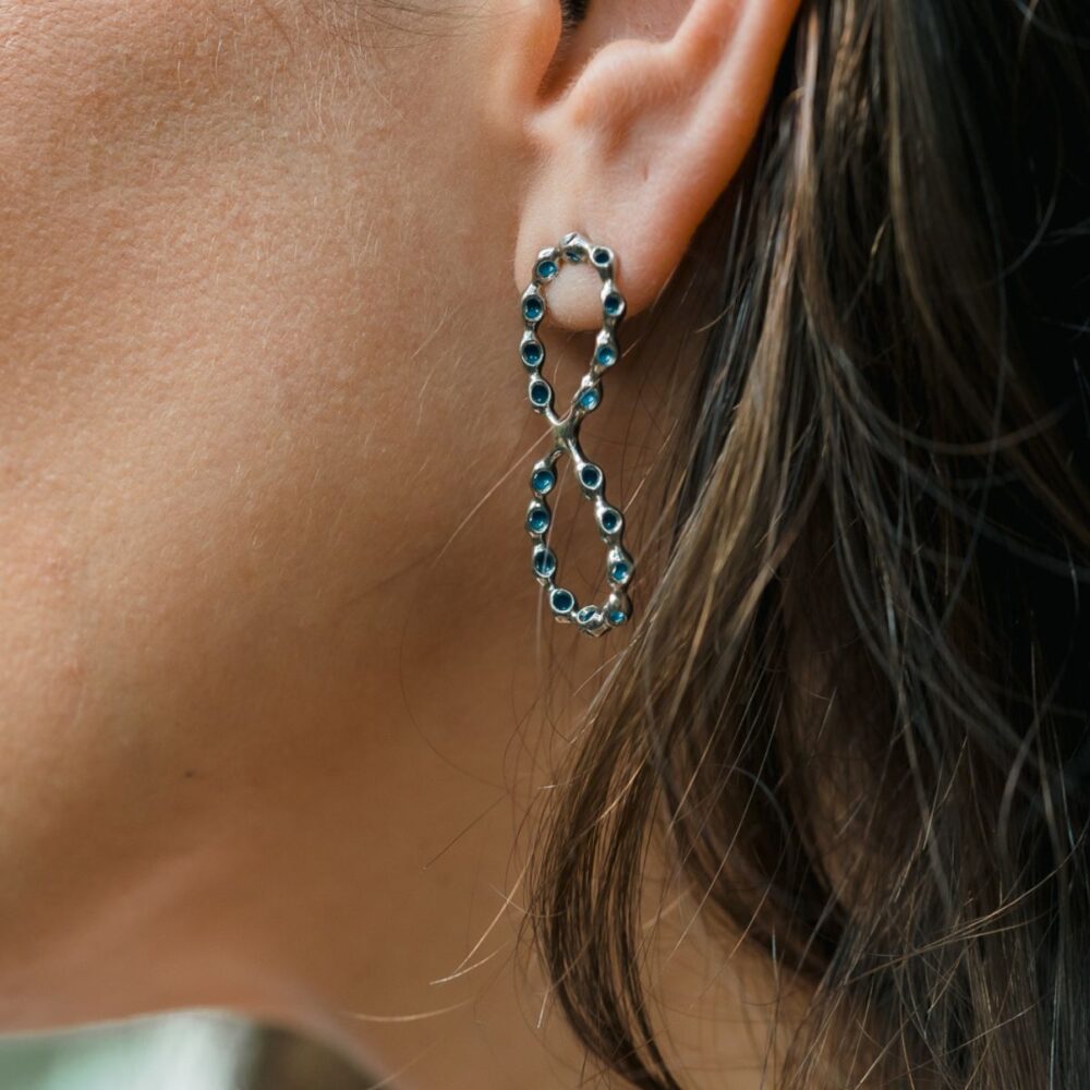 Elegant infinity heart earrings featuring blue gemstones, ideal for stylish, sophisticated looks.